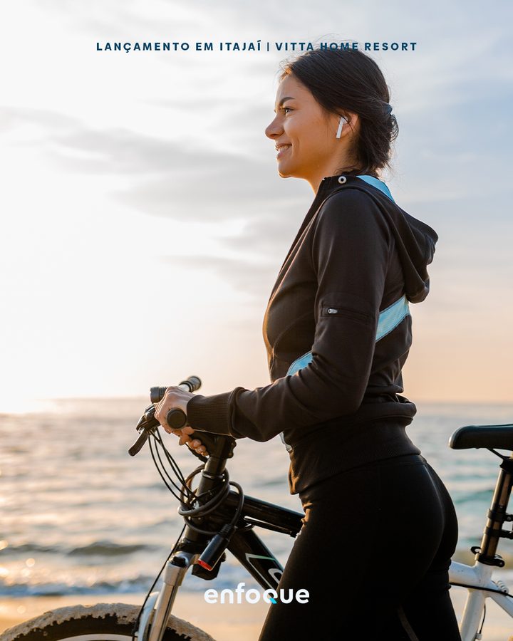 Peça do lançamento Vitta Home Resort, mulher com bicicleta à beira-mar.